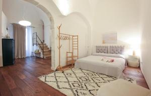 ein weißes Zimmer mit 2 Betten und einem Teppich in der Unterkunft Tea Tree Apartments 2 in Castellana Grotte