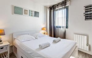 ein Schlafzimmer mit einem weißen Bett mit Handtüchern darauf in der Unterkunft 1 Bedroom Cozy Apartment In La Rochelle in La Rochelle