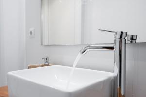 a kitchen sink with water coming out of a faucet at GuestReady - Homely stay in Porto in Porto
