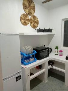 a kitchen with a counter with a microwave and a refrigerator at Uroa House in Uroa +5 photos