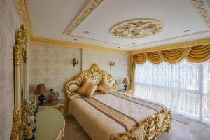 1 dormitorio con cama de oro y ventana en The Penthouse Seaview Rawai Beach Phuket by Benya Group - Free Airport Pick Up, en Phuket