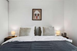 a bedroom with a large bed with two lamps at The Marina Suite Including 1x Free Private Parking Spot in Aarhus +17 photos