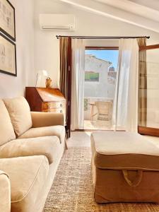 Una sala de estar con un sofá y una ventana grande. en La Casica, en Altea