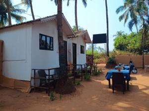 a small house with a table and a blue table cloth at Love paradice huts in Arambol