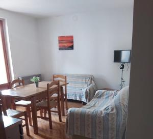 a living room with a table and a couch at Appartamento Belvedere in Azzone