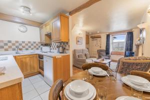 a kitchen and dining room with a table and chairs at Rose Bank Cottage Coniston in Coniston
