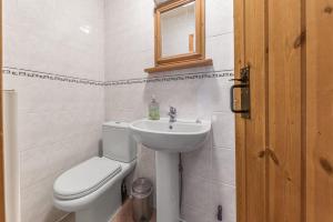 a white bathroom with a toilet and a sink at Rose Bank Cottage Coniston in Coniston +10 photos