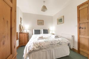 a bedroom with a large bed and a wooden door at Rose Bank Cottage Coniston in Coniston