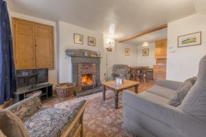a living room with a couch and a fireplace at Rose Bank Cottage Coniston in Coniston