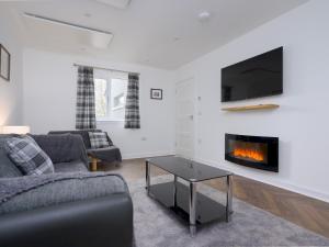 a living room with a couch and a fireplace at Golfers Haven Links Cottage Crail - Pass the Keys in Crail