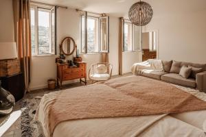 a bedroom with a bed and a couch and windows at Residenza Villa Genua in Bordighera