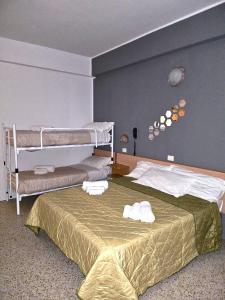 a bedroom with a bunk bed with towels on it at Hotel Villa Rosa in Misano Adriatico