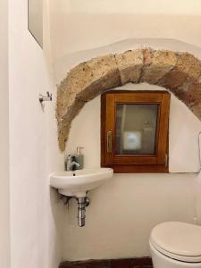 a bathroom with a sink and a toilet at Santa Monaca Medieval Guesthouse in Sorano +22 photos
