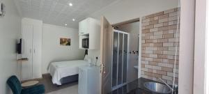 Un baño con una cama y un lavabo en una habitación. en Twinex Accommodation Bellville, en Stikland