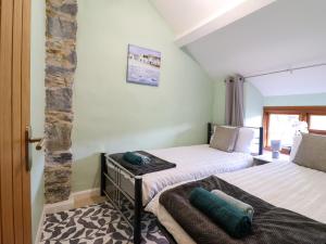 una camera da letto con due letti e un muro di pietra di Gwynfa a Betws-y-coed