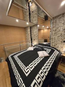 a bedroom with a black and white bed with a mirror at Romantic Room in La Mure