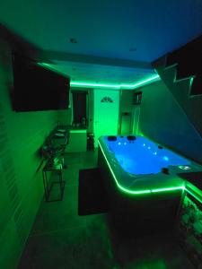 a room with a tub with a green lighting at Romantic Room in La Mure