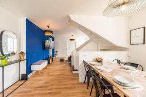 a dining room with a long table and a blue wall at Evasion Bretonne a Guingamp pour 12 personnes in Guingamp
