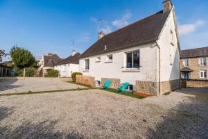 a white house with two blue chairs in the driveway at Evasion Bretonne a Guingamp pour 12 personnes in Guingamp +28 photos