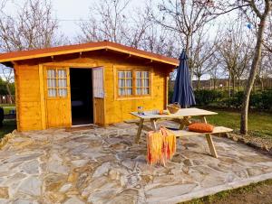 a small yellow shed with a picnic table in front of it at Camping Arribes del Duero in Lumbrales