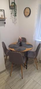 a dining room table with chairs and a clock on the wall at R&R studio in Cluj-Napoca