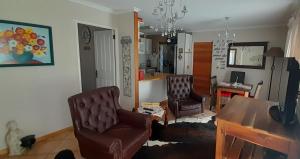 a living room with two chairs and a table at De Kleine Herberg in Durbanville