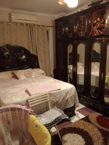 a bedroom with a bed and a dresser with mirrors at كومبوند جاردينيا النصر - التوسعات الشمالية 6اكتوبر in 6th Of October