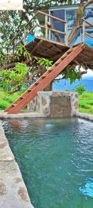 a wooden ladder sitting on top of a pool of water at A Mango Tree House with a private swimming pool in Tegallengah +76 photos