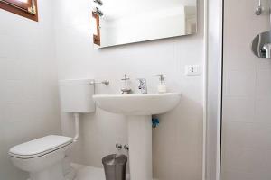 a white bathroom with a toilet and a sink at Apartment Mediterraneo - 120 in Musignano