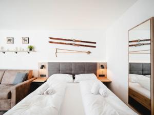 una camera con letto, divano e specchio di Glacier View a Kaprun
