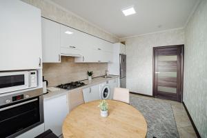 a small kitchen with a wooden table in it at Good location apartment in Chişinău