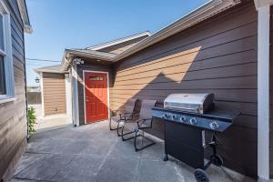 a backyard patio with a grill and a red door at Sq Urban Retreat in Sequim