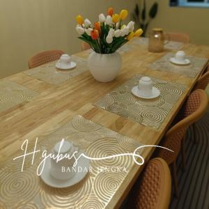 a wooden table with a vase of flowers on it at Homestay Gubus in Bandar  Pusat Jengka +1 photo