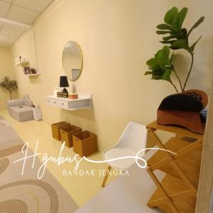 a room with a table and a chair and a mirror at Homestay Gubus in Bandar  Pusat Jengka