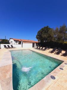 a swimming pool with chairs and a house at El Hogar de LELU in Quintes