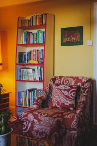 a living room with a couch and a book shelf with books at Penrhiw Farm B & B in Goodwick