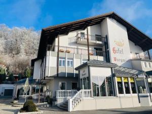 a large white building with a balcony at Hotel Burgwirt in Deggendorf