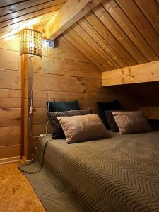 a bedroom with a bed in a wooden room at Domki na Łące in Ostrów Pieckowski