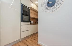 una cocina con un reloj en la pared junto a un mostrador en 2 Bedroom Gorgeous Apartment In Zadar, en Zadar