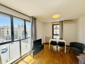 un salon avec une table et une grande fenêtre dans l'établissement El mirador de César Augusto, à Saragosse