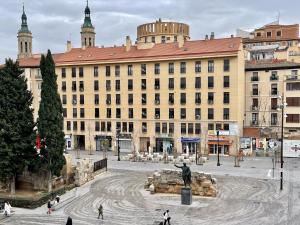 un grand bâtiment avec une statue devant lui dans l'établissement El mirador de César Augusto, à Saragosse
