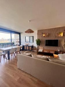 ブルージュにあるAppartement T2 au bord du lacのソファのあるリビングルームとダイニングルーム