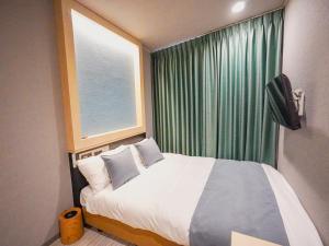 a bedroom with a large bed and a window at The GALA Hotel Umeda in Osaka