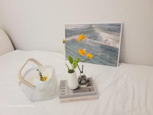 a table with a picture and flowers on a bed at Stay Yuyeon in Busan