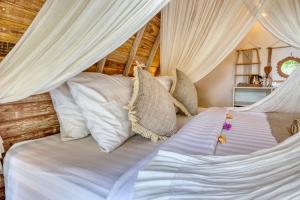 a bedroom with two beds with white curtains at Nature Hill Penida in Nusa Penida