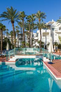 a swimming pool with palm trees and buildings at Apartamentos Urb, La Alcazaba 614 y 642 Banus Marbella in Marbella