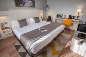 Un dormitorio con una cama grande y una silla amarilla. en SERHS Carlit Boutique Hotel, en Barcelona