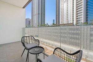 une chambre avec deux chaises et une table sur un balcon dans l'établissement Silkhaus modern 1BDR in Downtown with balcony, pool, gym, à Dubaï
