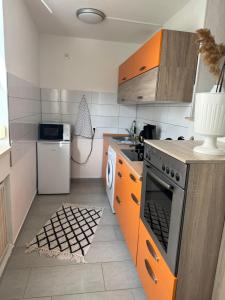 a kitchen with orange cabinets and a stove at Ferienwohnung Antonia in Bad Neuenahr-Ahrweiler