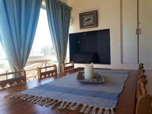 Sala de estar con mesa con velas y TV en Golfbeach Luxury self catering apartment, en Ciudad del Cabo